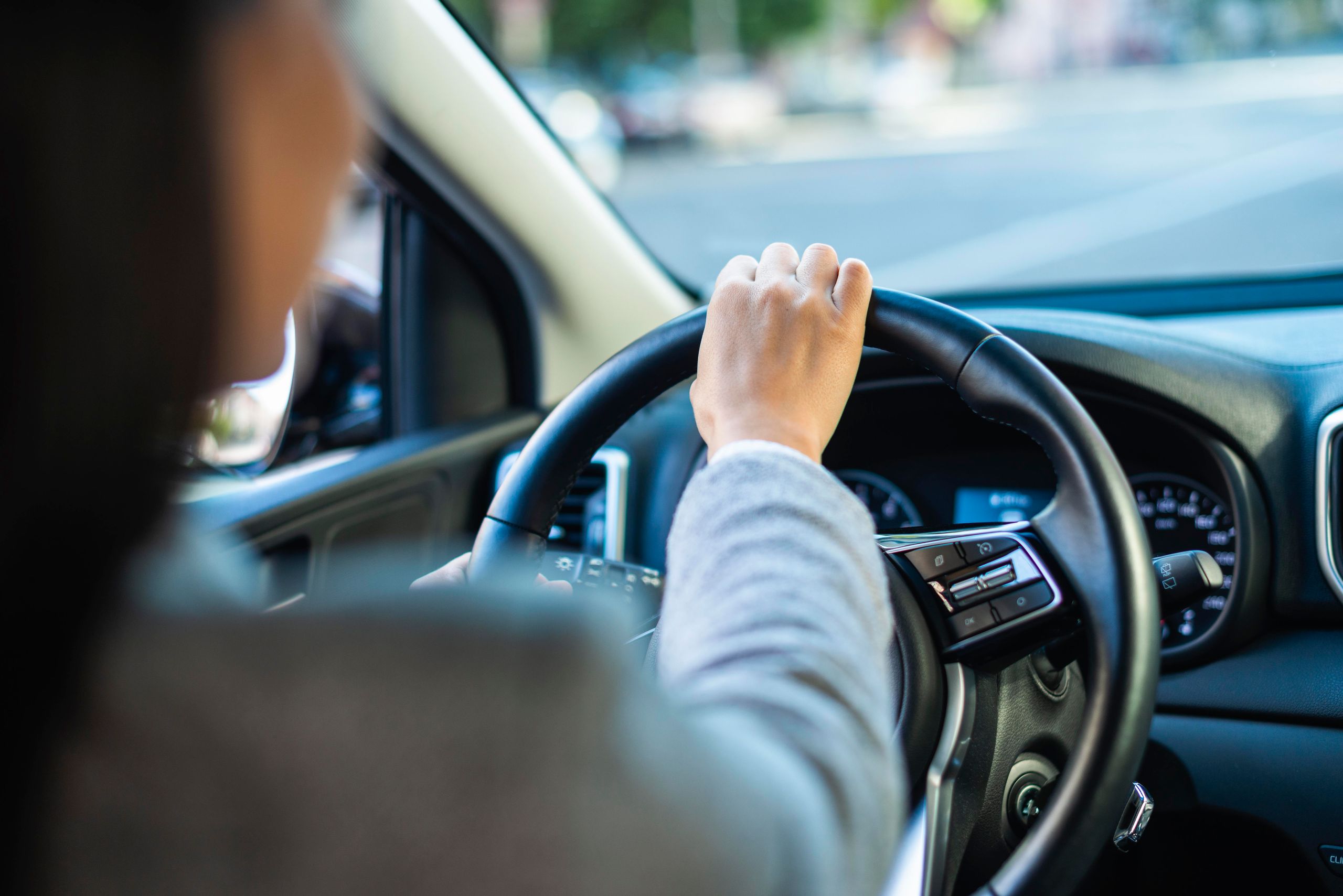 Conductor con ambas manos en el volante durante la conducción de un vehículo