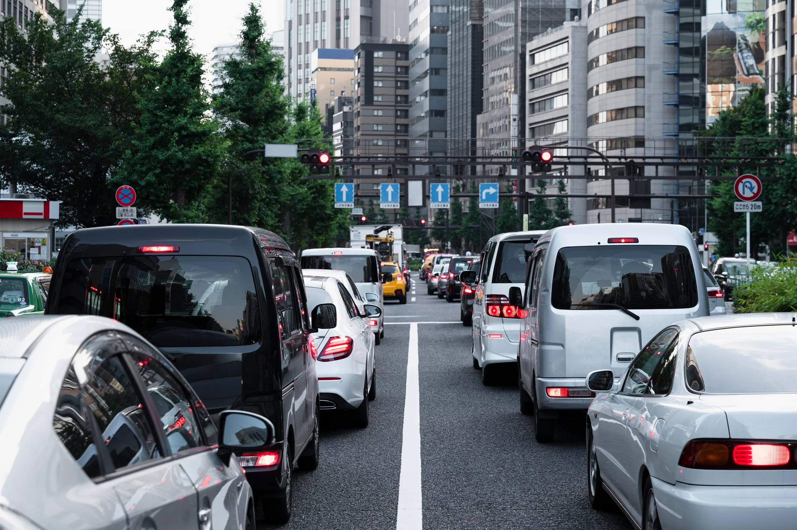 Tráfico denso en ciudad con coches de diferentes emisiones circulando juntos por calle