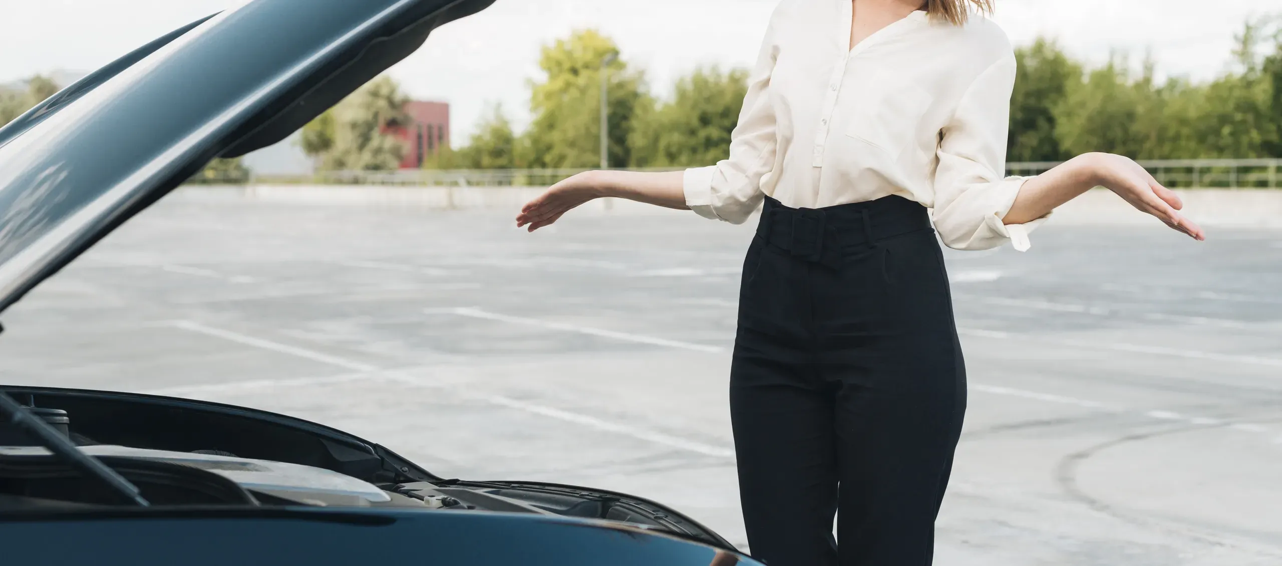 Mujer mostrando gesto de frustración ante coche averiado con capó abierto