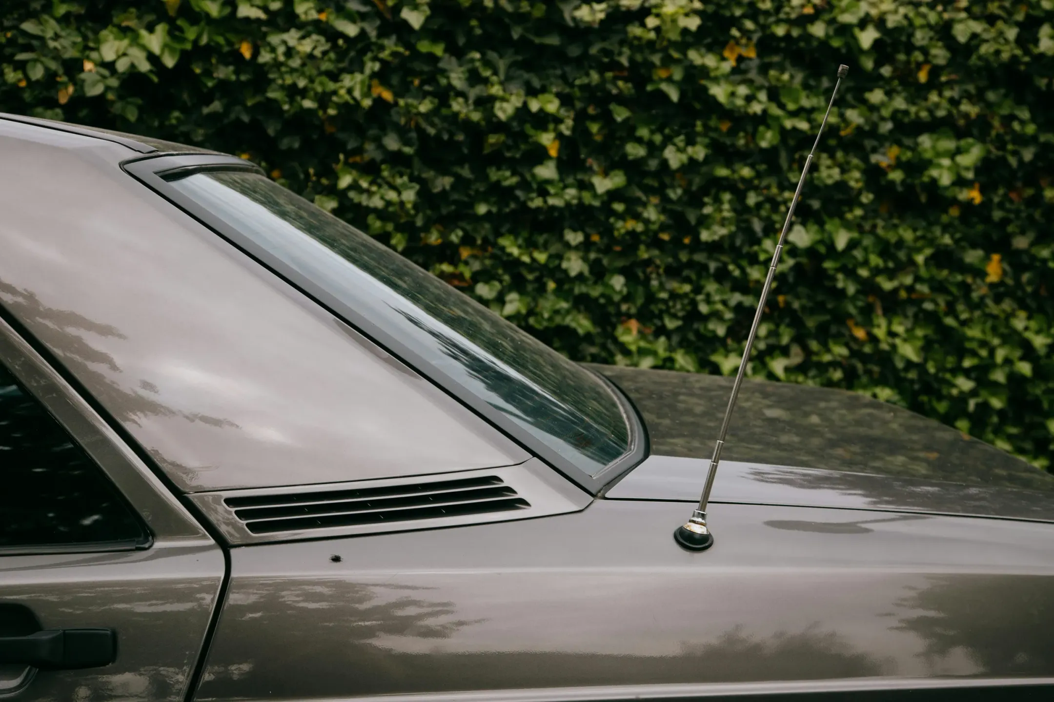 Antena de radio metálica en el techo de un coche gris