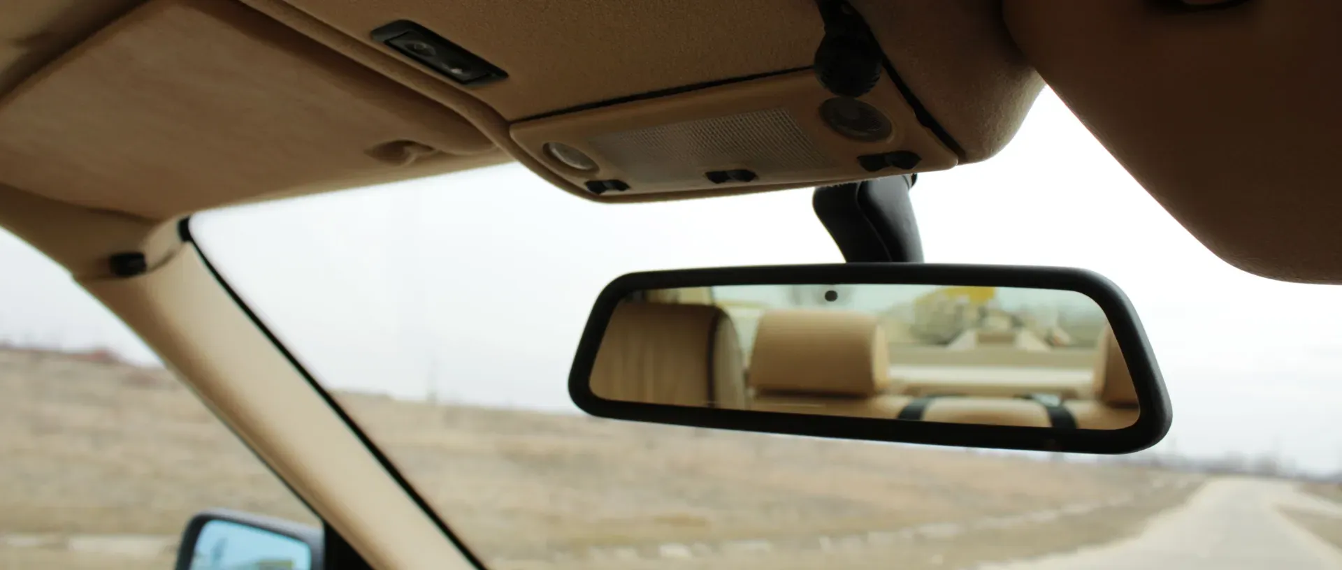 Espejo retrovisor interior de un coche mostrando la vista trasera de la carretera