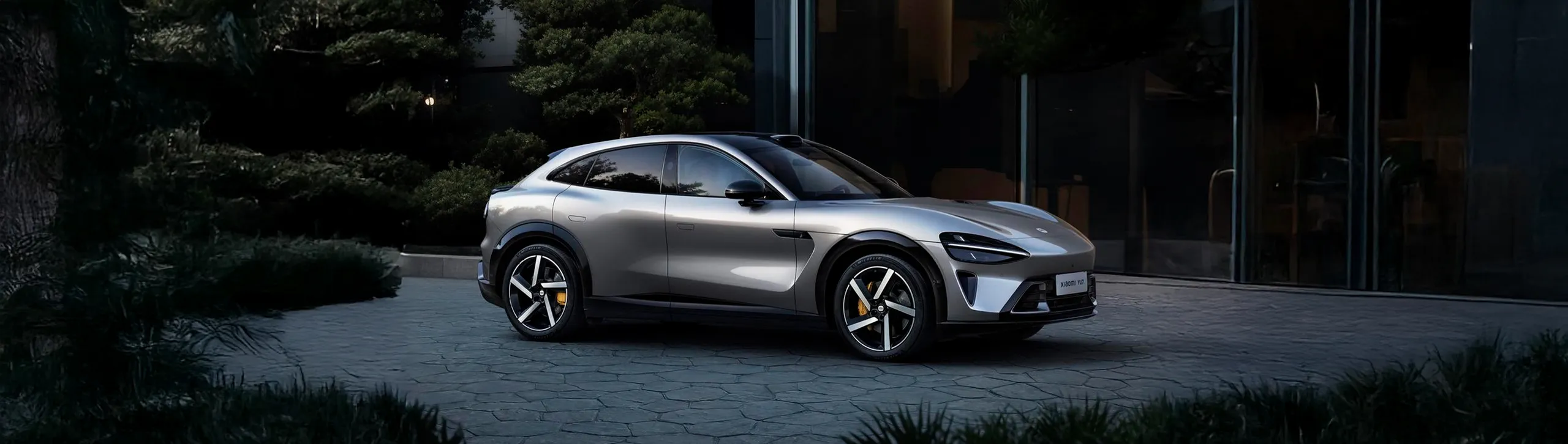 Xiaomi YU7 SUV eléctrico blanco aparcado en zona moderna con vegetación