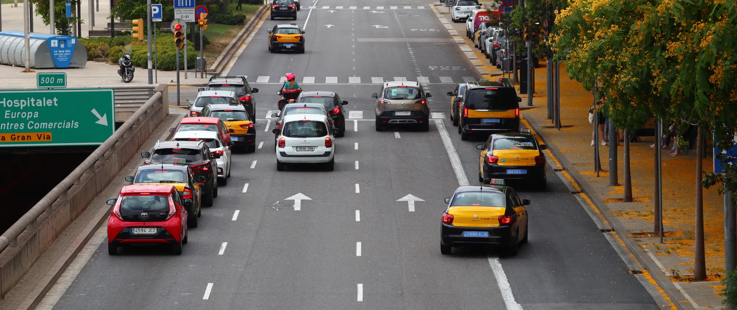 Taxis y vehículos en zona de bajas emisiones de Barcelona circulando por avenida urbana