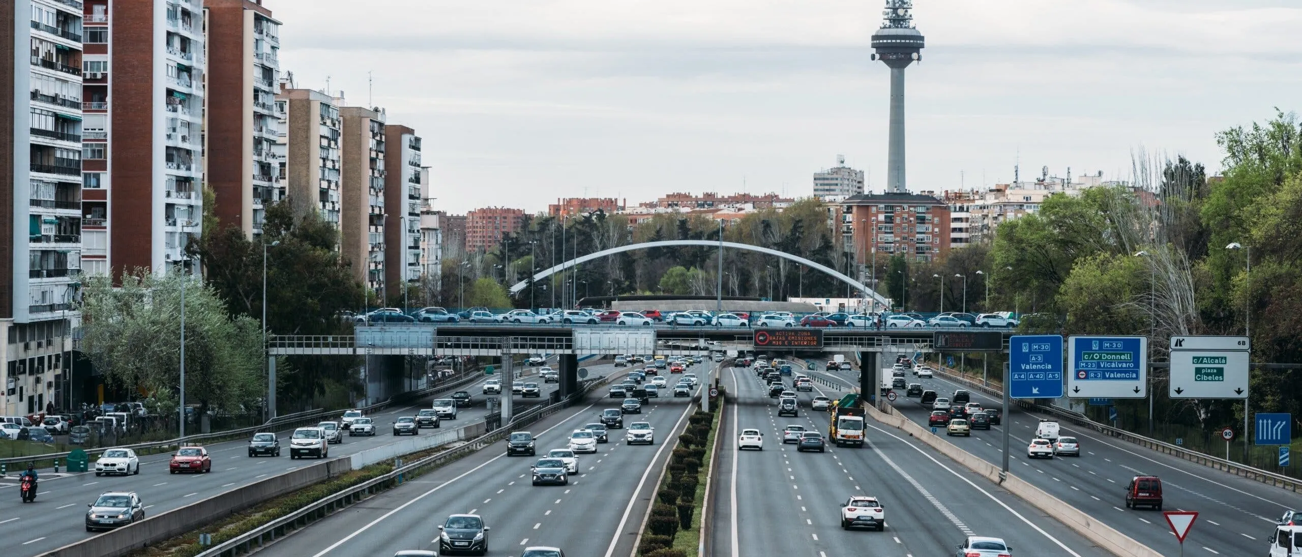 Autopista urbana congestionada con múltiples carriles y vehículos circulando bajo